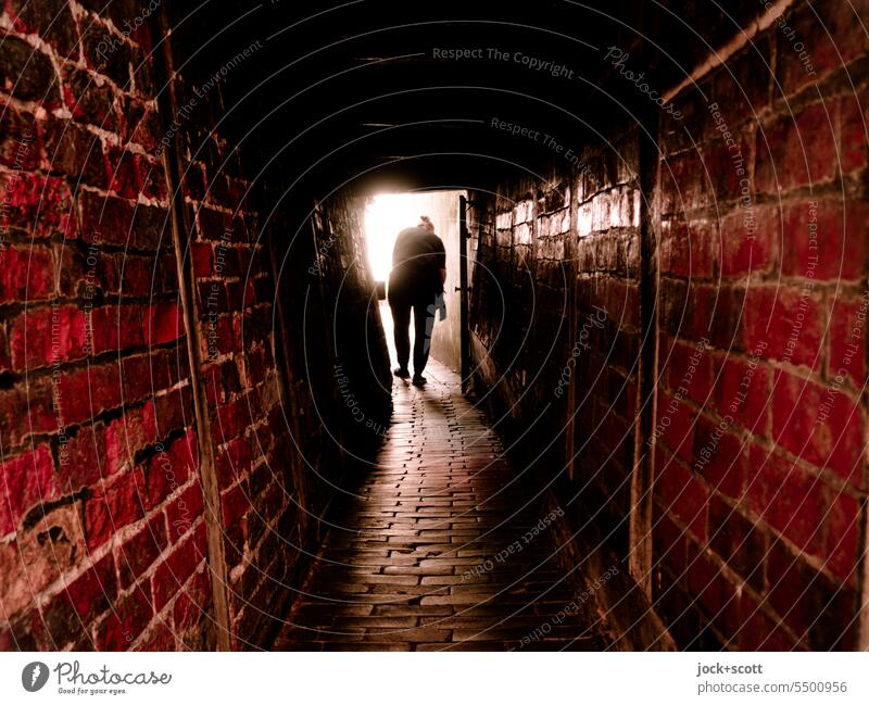 a narrow and narrow alley leads to the light Pedestrian Lübeck Historic Old town Architecture Lanes & trails Alley Silhouette Back-light Tunnel vision Corridor