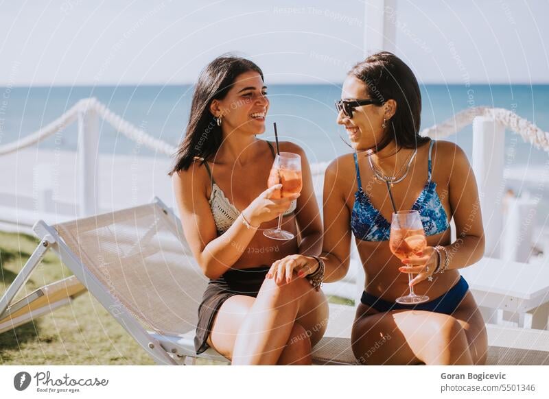 Smiling young women in bikini enjoying vacation on the beach happy sun sunglasses attractive people lifestyle leisure friendship together outdoors woman travel