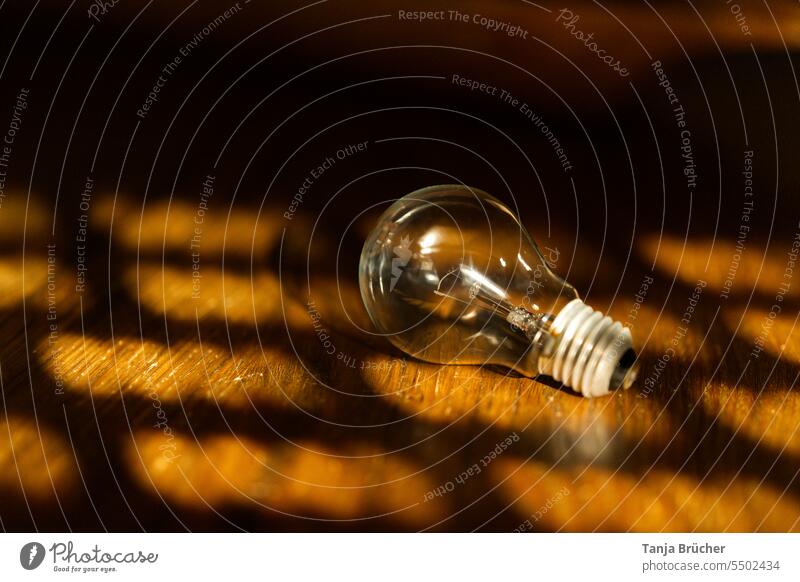 Light bulb on a wooden table in the evening light Electric bulb Light and shadow Light and shadow play light and dark Shadow light & dark Shaft of light