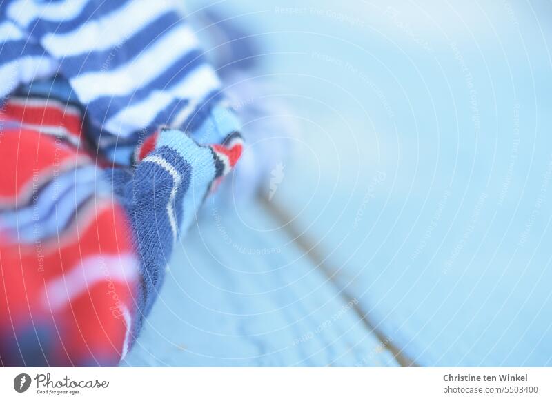 a red, white and blue striped cloth on light blue wood Cloth Red White Striped fabric red white blue Pattern Maritime Blue Exterior shot Wood backing Material