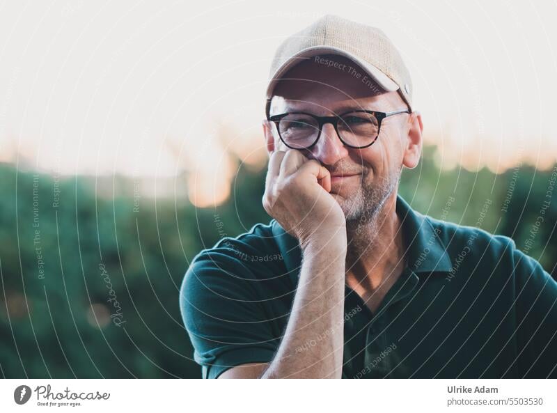 Drinkje bej Inkje | The rogue - man looks mischievously at the camera , wears a capy and rests his chin on naturally Congenial Chin up Eyeglasses Adults Man