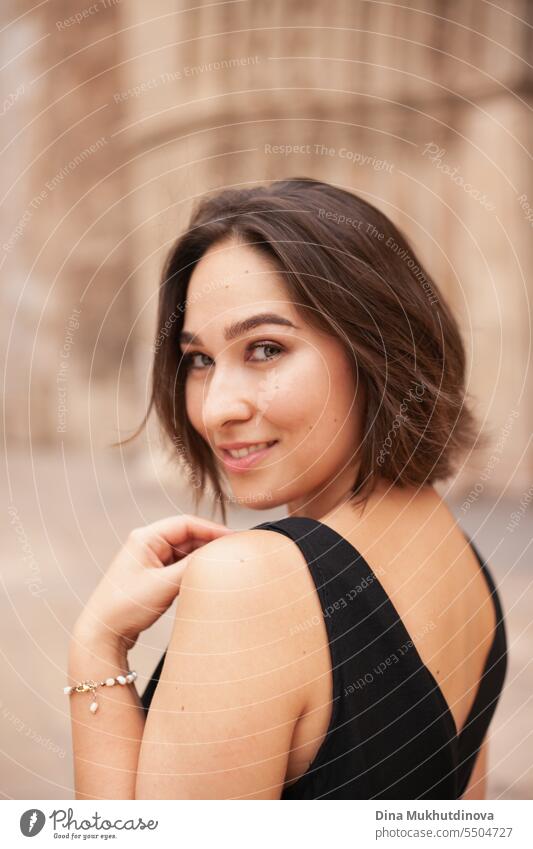 retro portrait of a smiling woman closeup. Beautiful woman at street of historic town. Gorgeous girl sightseeing in Europe. Confident woman, solo female traveler. Glamour and chic, fashion and style concept.