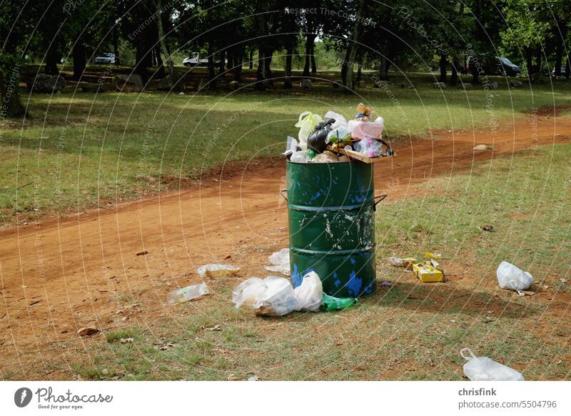 Filled garbage can at sunbathing lawn Trash ton dustbin filth Disposal holidays Bathroom lido waste Recycling Waste management Environmental protection