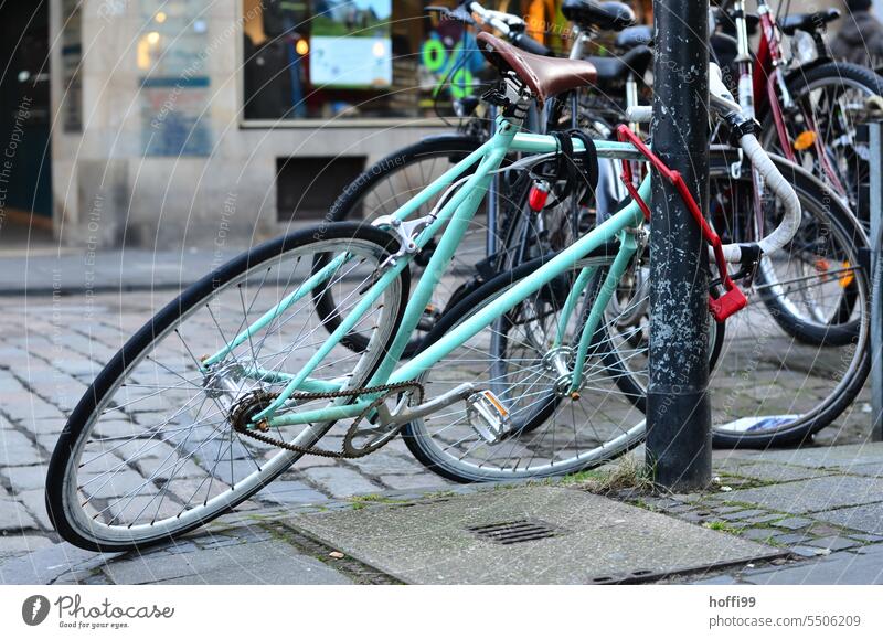 sleek city bike in inclined position on lamppost Wheel Cycling completed Inclined position Lifestyle Bicycle Transport Means of transport Tire Hip & trendy