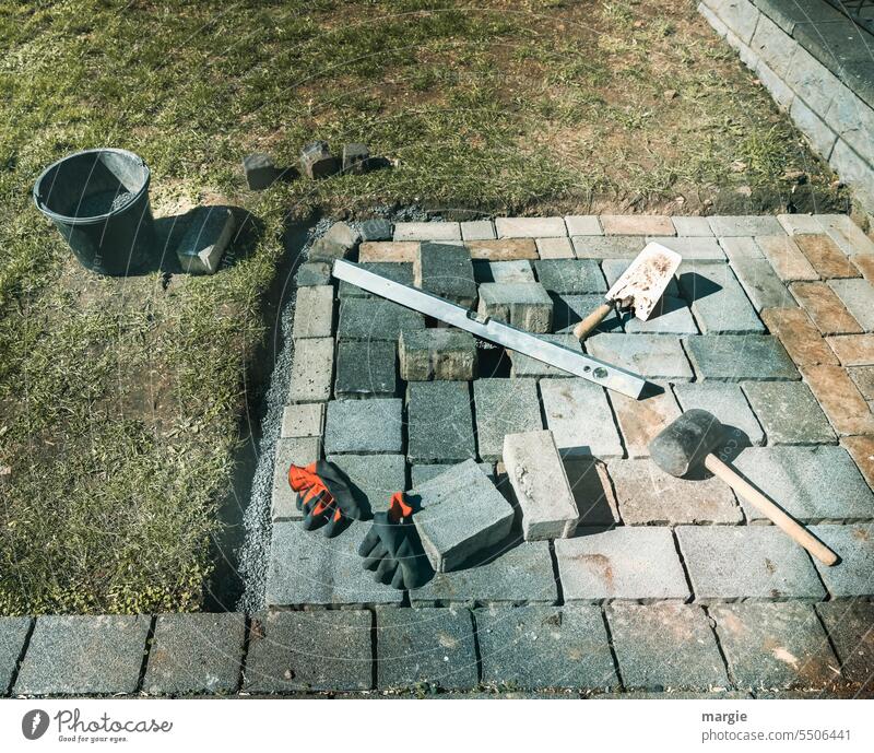 Construction site: paving a square pavement Paving stone Deserted Exterior shot Lanes & trails Garden Work gloves Hammer ladle Build Bucket Stone