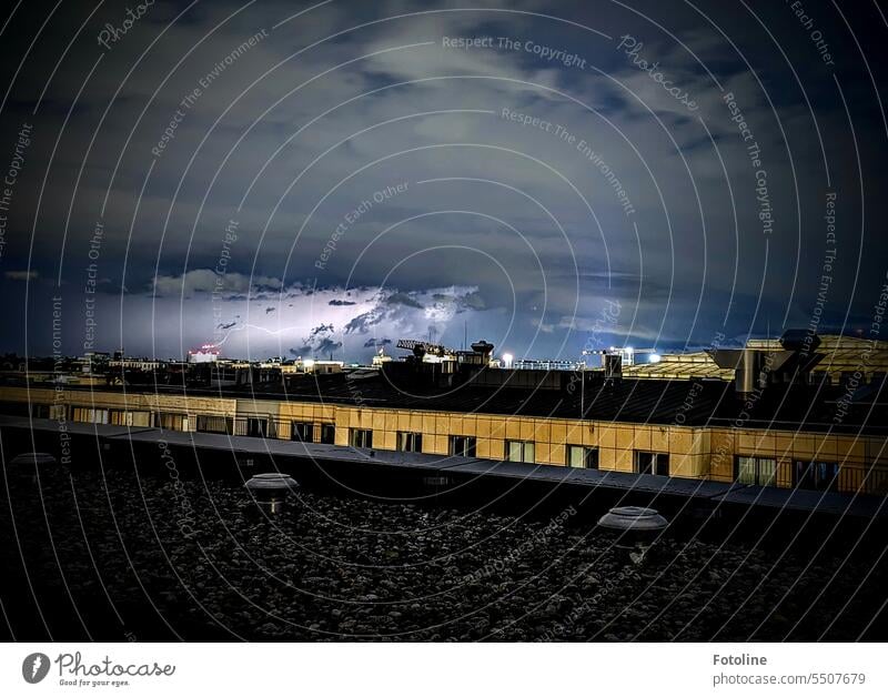 A thunderstorm is brewing over the rooftops of Berlin. Lightning illuminates the sky in the background. The first one I was able to capture in a photo. Town