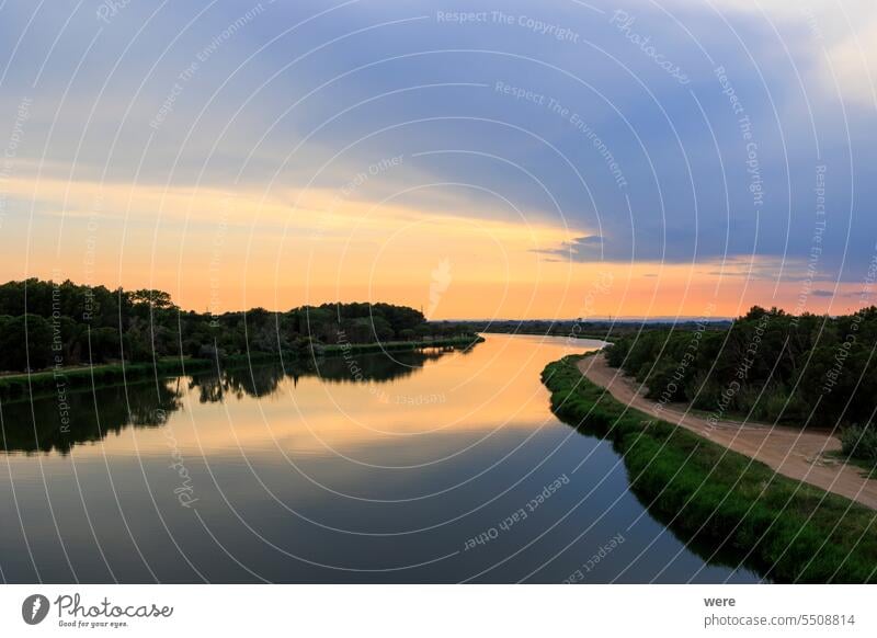 Colorful sunset over the water of the Canal du Rhone near Aigues-Mortes in Carmarque Camarque Canal du Midi Canal du Rhône à Sète France Gard department H2O