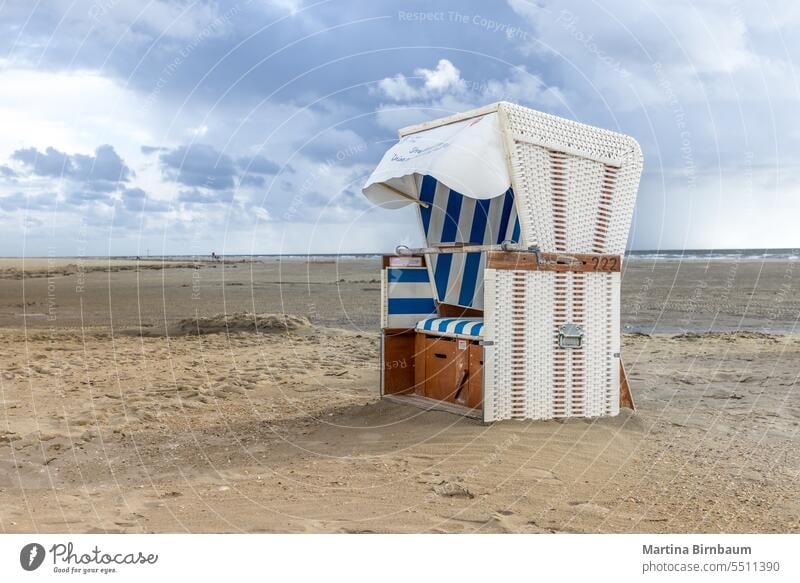 Hooded beach chair on the beach at the north sea beach chairs hooded beach chair strandkorb sand coast nature vacation summer sun holiday tourism recreation