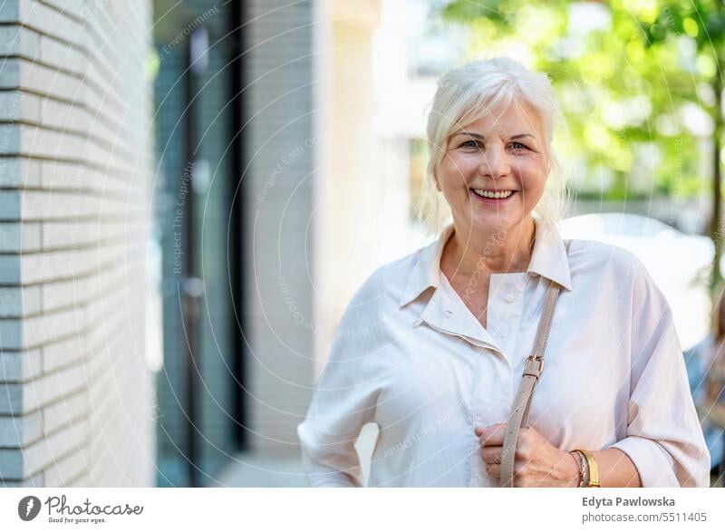 Portrait of happy senior woman standing in the city people caucasian healthy city life gray hair enjoy street casual day portrait outside real people