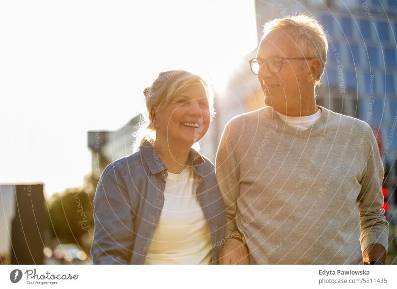 Senior couple in love walking in the city people caucasian standing healthy city life gray hair enjoy street casual day portrait outside real people