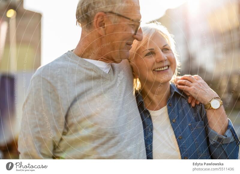 Senior couple in love walking in the city people caucasian standing healthy city life gray hair enjoy street casual day portrait outside real people