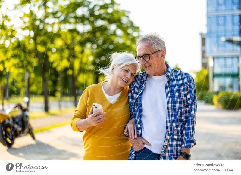 Senior couple in love walking in the city people caucasian standing healthy city life gray hair enjoy street casual day portrait outside real people