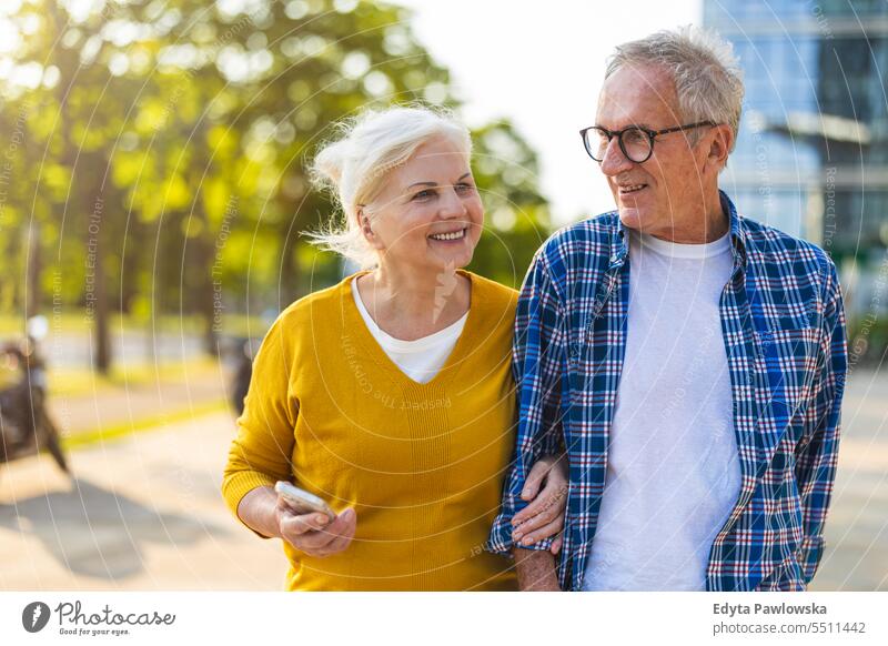 Senior couple in love walking in the city people caucasian standing healthy city life gray hair enjoy street casual day portrait outside real people