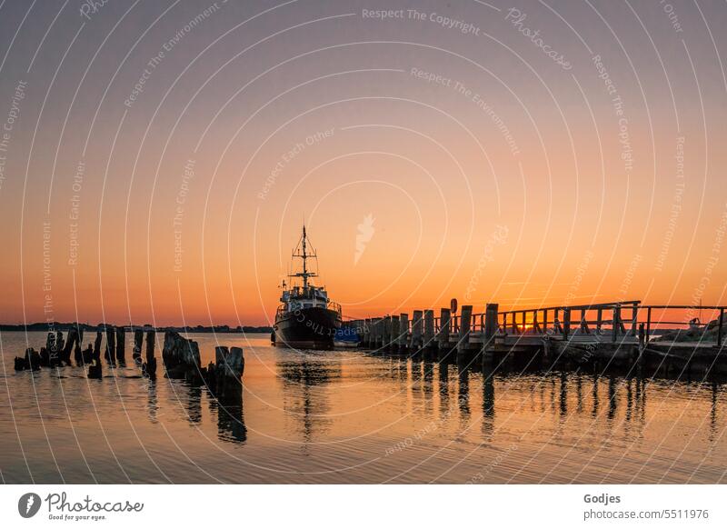 Maritime sunset. Ship is anchored at the jetty. Reflections of the wooden planks on the water ship Sunset Wood planks reflection Evening sun Vacation & Travel