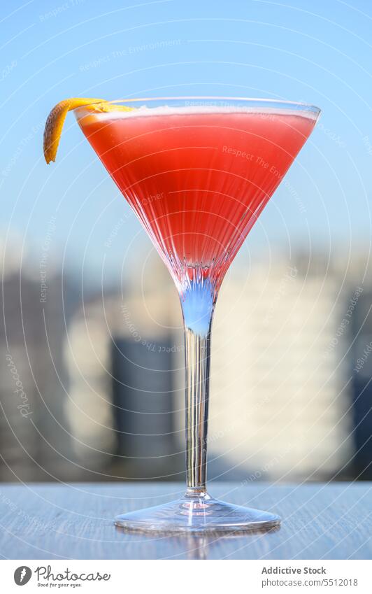 Cosmopolitan cocktail with lemon peel alcohol cosmopolitan citrus glass liquid aperitif cityscape fizz red martini glass sky tasty fruit drink portion beverage