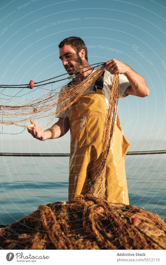 Fisherman fishing in open sea from sail boat fisherman net schooner work uniform male soller balearic islands mallorca seine fish focus hunt trawler ship yacht