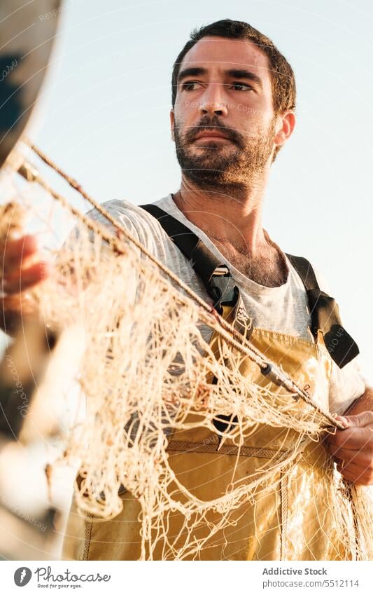 Fisherman fishing in open sea from sail boat fisherman net portrait schooner work uniform male soller balearic islands mallorca seine fish hunt trawler ship