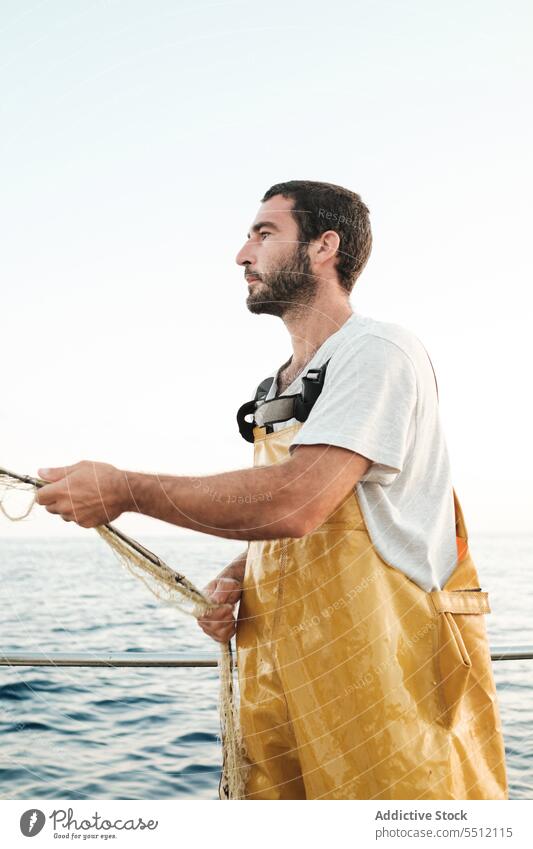 Fisherman fishing in open sea from sail boat fisherman net schooner work uniform focus male soller balearic islands mallorca seine fish hunt trawler