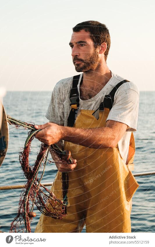 Fisherman fishing in open sea from sail boat fisherman net schooner work uniform male soller balearic islands mallorca seine fish focus hunt trawler ship yacht