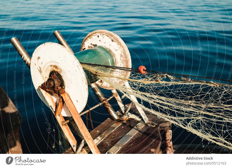 Net attached to fishing equipment near sea water net coil marine ripple summer ocean soller balearic island mallorca blue metal rust nature mesh environment