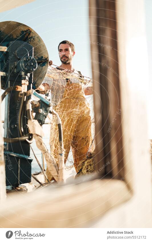 Fisherman fishing in open sea from sail boat fisherman net schooner work uniform male soller balearic islands mallorca seine fish hunt trawler ship yacht