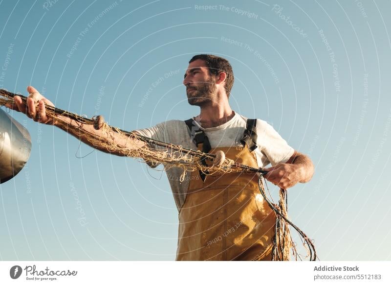 Fisherman fishing in open sea from sail boat fisherman net schooner work uniform male soller balearic islands mallorca seine fish hunt trawler ship yacht