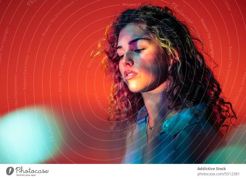 Attractive woman with curly hair in room with neon lights portrait effect illuminate dot calm peaceful tranquil sensual young female lady long hair human face