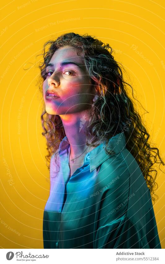 Attractive woman with curly hair in room with neon lights portrait effect illuminate dot calm peaceful tranquil sensual young female lady long hair human face