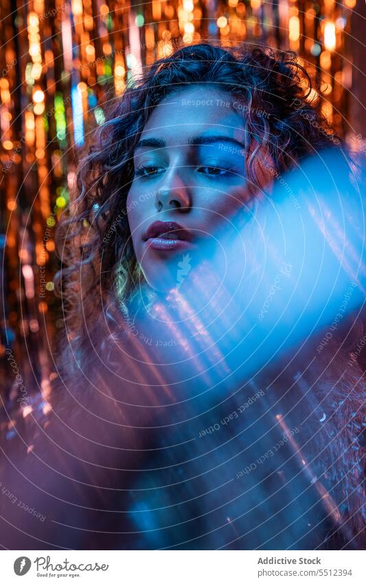 Attractive woman with curly hair in room with neon lights portrait effect illuminate dot calm peaceful tranquil sensual young female lady long hair human face