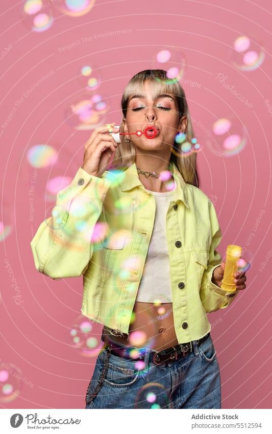 Young woman blowing soap bubbles in studio entertain fun having fun portrait childish free time studio shot model female young choker style piercing casual