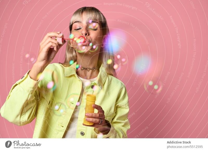 Young woman blowing soap bubbles in studio entertain fun having fun portrait childish free time studio shot model female young choker style piercing casual