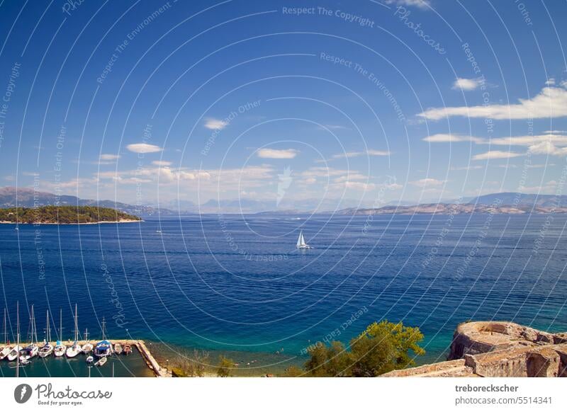 View over the picturesque bay of Corfu Gouvia with light feather clouds, blue sky and water sailboat panorama kerkyra corfu gouvia sea landscape nature coast