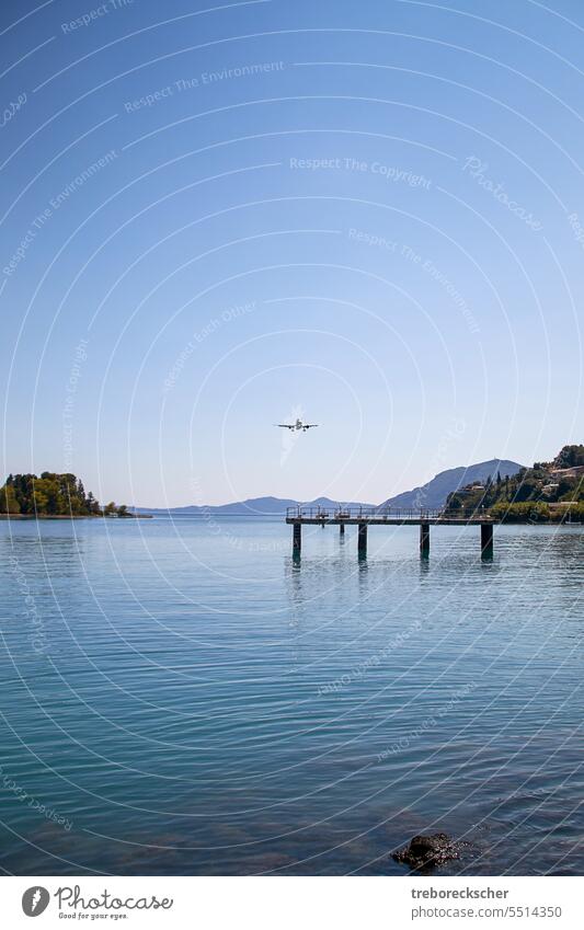 Approach of an airplane over a sea bay to Corfu airport landing travel tourism flight sky airline ocean close near corfu kerkyra greece platform transportation