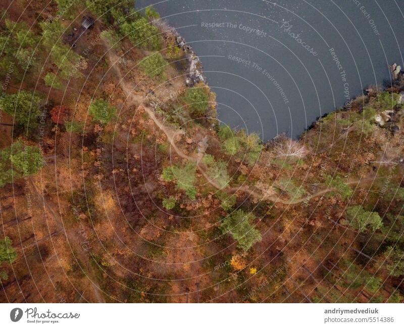 Picturesque aerial view of landscape with emerald lake and rocks in the middle of a coniferous autumn forest in Korostyshiv granite quarry, Zhytomyr district, northern Ukraine. Zhytomyr canyon