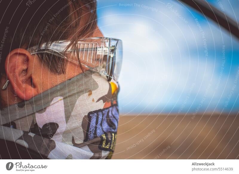 Side shot of middle-aged man wearing goggles and mouth guard during off-road ride Man Saftey goggles Mask Dust dust protection Driving Running Rally action dirt