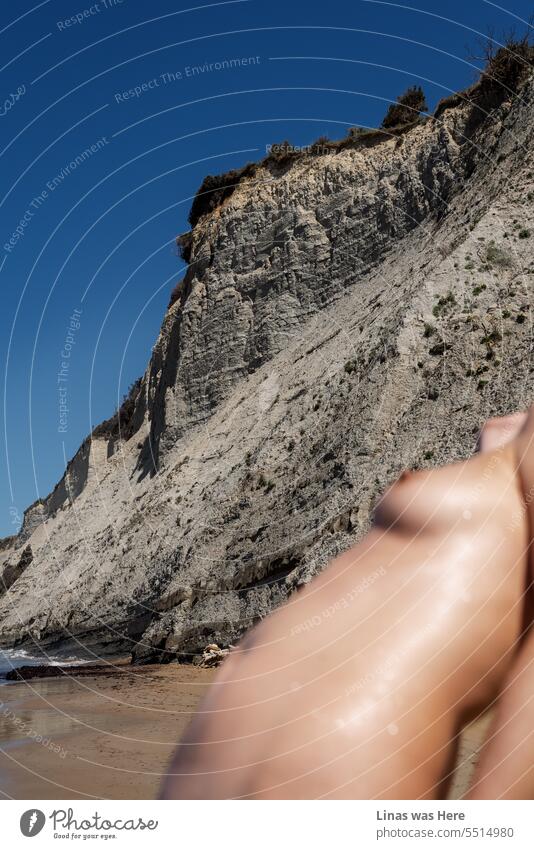 It’s great weather outdoors by the sea in Corfu, Greece. And a gorgeous naked girl is making the temperature rise even more. Her sexy curves, rocky coastline, and blue sky work well together. An erotic image of ageless women’s beauty.