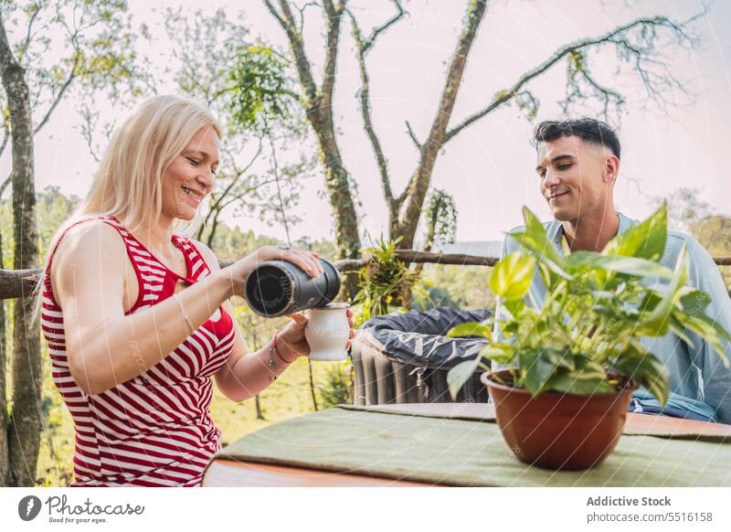 Couple having tea on cozy terrace in sunlight couple mate leisure together rest cup pour relax weekend teatime chill adult mature herbal tea recreation positive