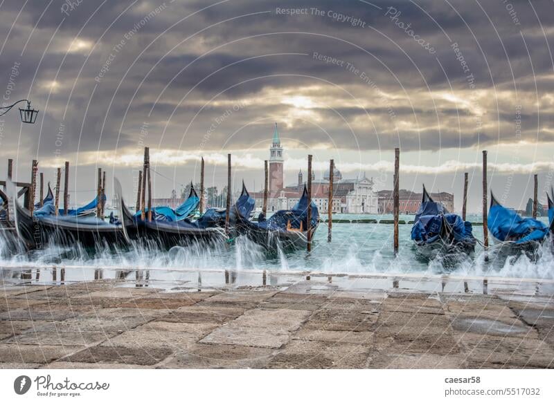 Moored Gondolas during High Tide at the St Marks Square, Venice poles veneto bollards gondolas splash quay move aqua alta long exposure wave boat movement