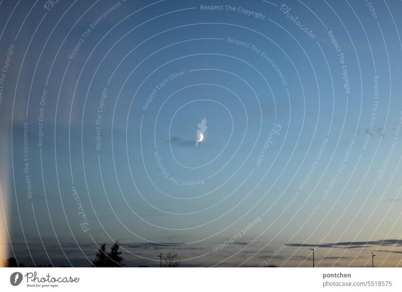 view through a window. the moon has risen. crescent moon in the evening sky Moon sickle Evening inside Window outlook Sky Celestial bodies and the universe