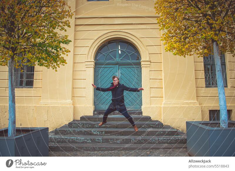 Middle-aged man in autumnal clothes jumping in the air in front of a historical house in Koblenz Autumn Autumnal germany trip home leave Man middle-aged man