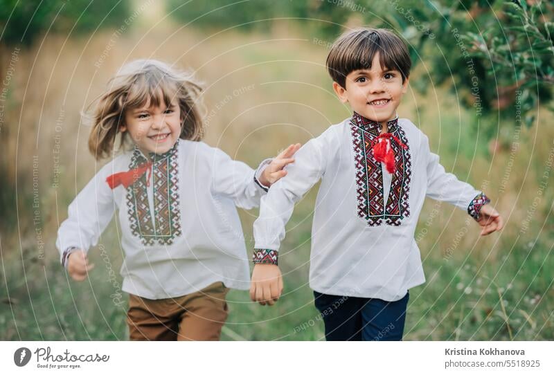 Little happy boys friends cheerfully running together along path in apple garden family play kid running child summer day happy family outside park