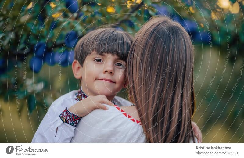 Portrait of beautiful ukrainian family 4 years old boy, mother in plum orchard mom son happy ukraine hug love parent care happiness hugging motherhood