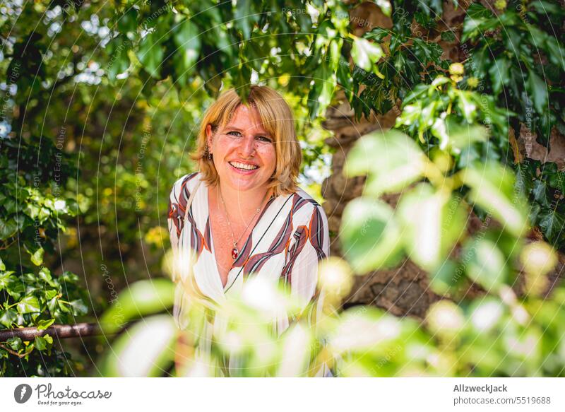 Portrait of a middle-aged blonde woman in the middle of a natural green backdrop Blonde blonde hair Woman Middle aged woman pretty Attractive Congenial portrait