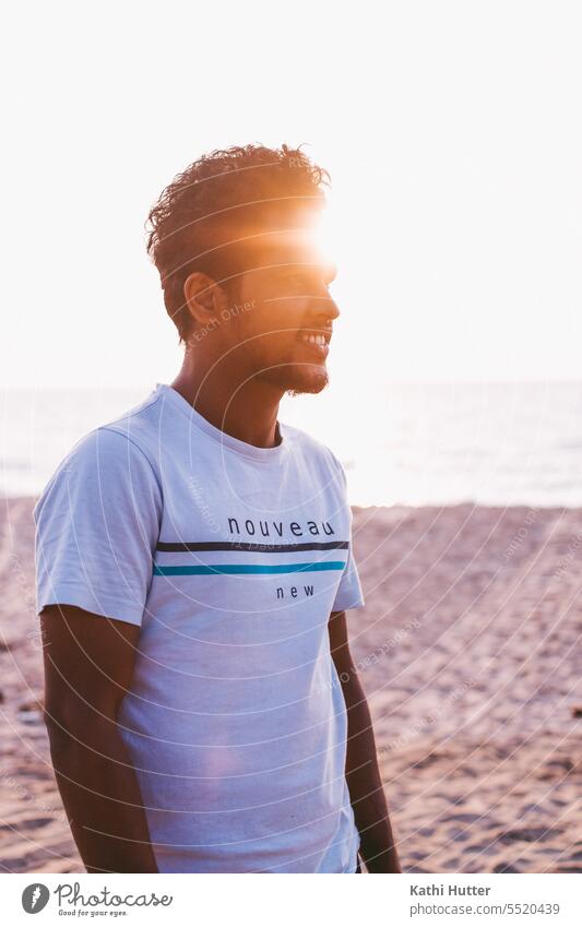 A young man by the sea with wind in his hair and the sunset. Man Sunset Light Sky Shadow Evening Silhouette Sunlight Exterior shot Beautiful weather Environment