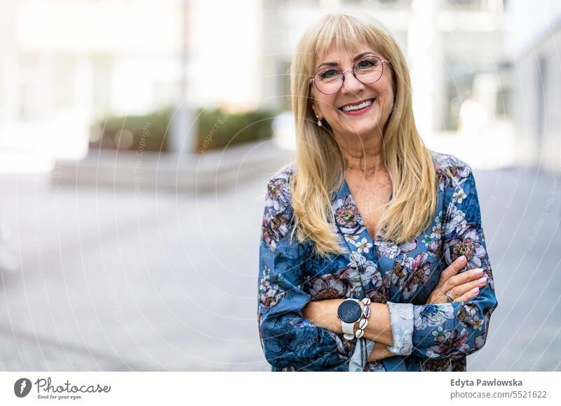 Portrait of a happy senior woman in eyeglasses standing outdoors natural enjoy satisfied cheerful confident pensioner outside elderly happiness older retired