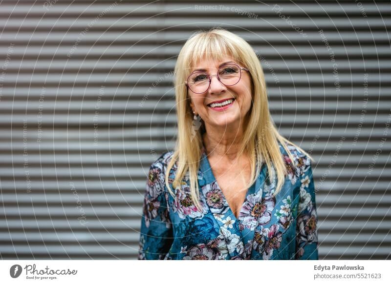 Portrait of a happy senior woman in eyeglasses standing outdoors natural enjoy satisfied cheerful confident pensioner outside elderly happiness older retired