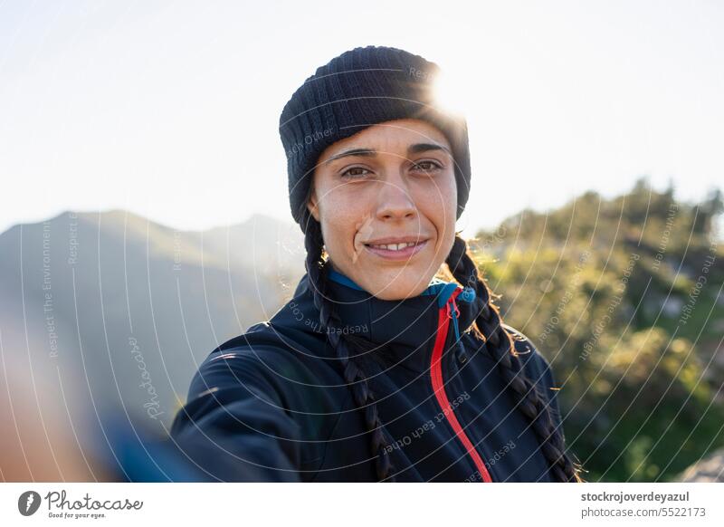 A young woman, mountaineer, warm from the cold, takes a selfie while enjoying the scenery and nature person beauty female happy caucasian portrait lifestyle