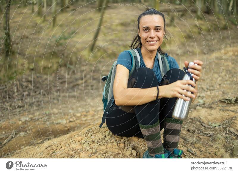 A young woman, hiker, enjoys the tranquility and silence of nature, while drinks water female person adult forest caucasian outdoors beauty lifestyle park