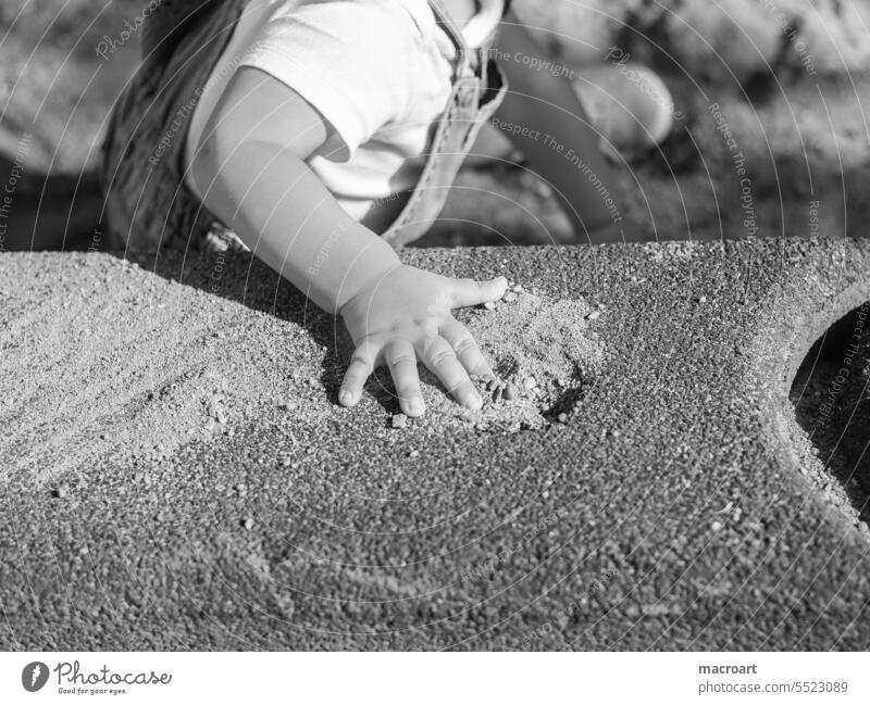 Child hand on a stone in a playground closeup Children`s hand Hand Playground black-white Fingers Infancy upbringing children detail Toddler Playing Parenting