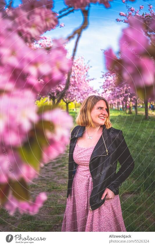 Portrait of smiling young blonde woman next to flowering cherry blossom branch portrait Woman Middle aged woman Young woman blonde hair blonde girl Blonde